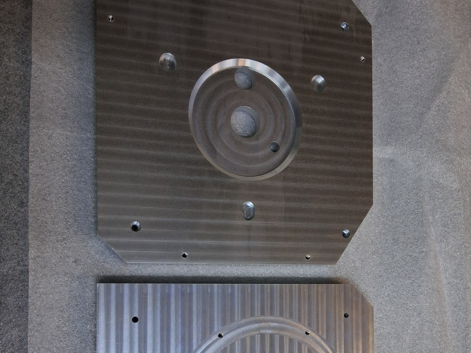 Two CNC-machined 6061 aluminum chamber floor plates with circular sealing features, precision holes, and clear chromate finish